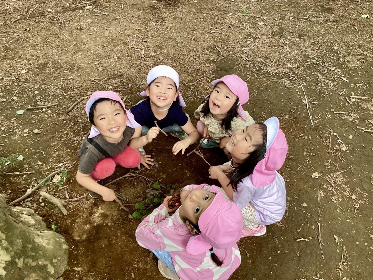 園庭で輪になって遊ぶ子どもたち